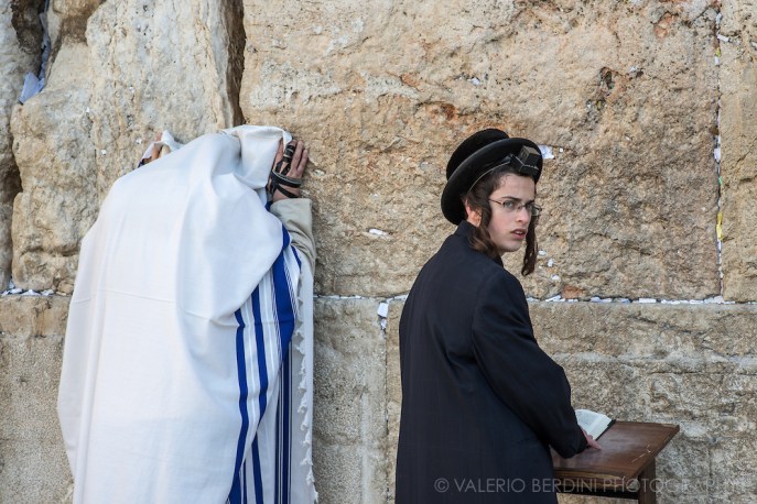 上图:哭墙晨祷。左边的男人披着祷告巾(Tallit Shawl),右手缠着经文匣(Arm Tefillin)。右边的男孩前额头上戴着经文匣(Head Tefillin)。经文匣里面藏着「示马」经文(申六4-9;十一13-21)。