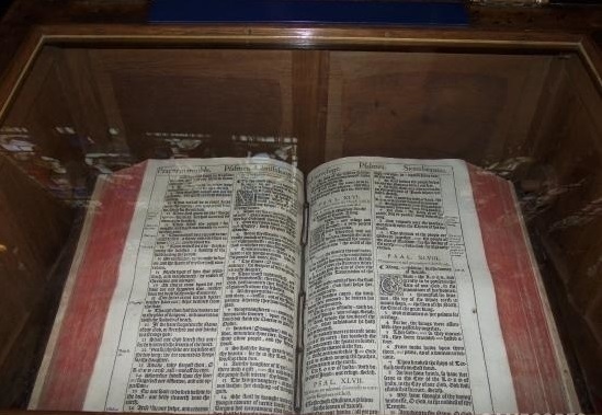 上图:莎士比亚生前使用的1611年KJV英王钦定本圣经,收藏在圣三一教堂(Church of the Holy Trinity, Stratford-upon-Avon)内莎士比亚墓的旁边,特地被打开在诗篇四十六篇。在KJV圣经中,诗篇四十六篇的第46个单词是「战抖 Shake」(诗四十六3),倒数第46个单词是「枪 Spear」(诗四十六9,古英语拼作Speare),合起来正好是莎士比亚的名字ShakeSpeare。此外,KJV圣经于1610年完成翻译,当时莎士比亚正好46岁。因此,有人认为莎士比亚参与了诗篇四十六篇的KJV版翻译。