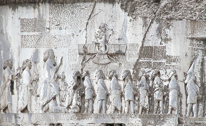上图:贝希斯敦铭文(Behistun Inscription)是刻在伊朗贝希斯敦山崖上的多语言铭文,由波斯阿契美尼德帝国大流士一世所立,记录了他镇压高墨达(Gaumata)政变和各地反叛、取得王位的经过。石刻上有描绘大流士一世脚踏高墨达的浮雕,周围的铭文以三种不同的楔形文字写成:古波斯语、亚兰语和巴比伦语。这个石刻有如罗塞塔石碑之于埃及象形文字一样,极大地帮助了专家们破解楔形文字。1835年,英国人罗林森(Sir Henry Rawlinson)拓取了石刻上的古波斯文铭文,1844年又拓取了其余的铭文。在他和其他学者的努力下,古波斯文铭文首先被成功解读,其它两种铭文随后也被成功解读。