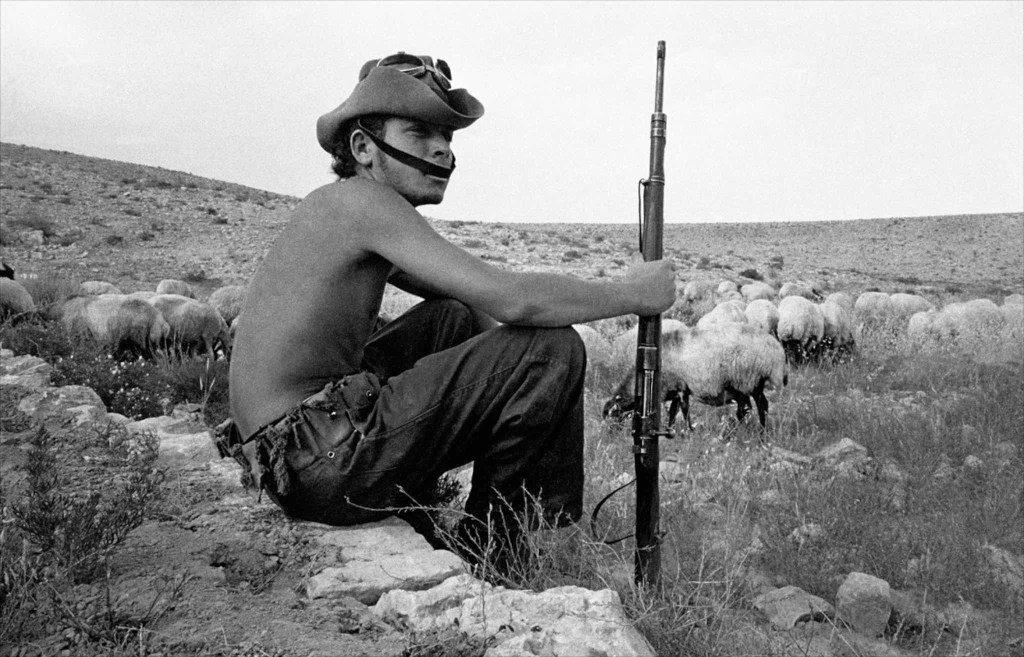上图:1954年在以色列南地旷野中的武装牧羊人(摄影:Frank Horvat),一边牧羊、一边保卫基布兹农场。以色列1948年复国之后,马上就遭遇了第一次中东战争,不采取全民皆兵就无法生存。
