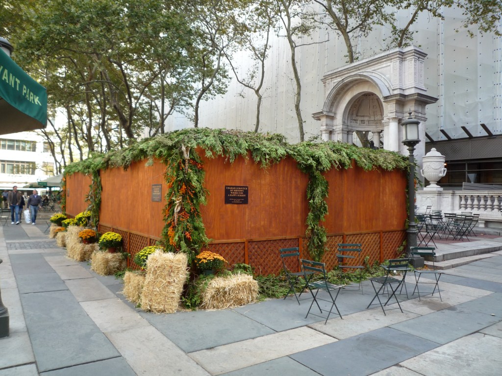 上图:纽约街头的住棚节棚子(Sukkah),上面只有一层薄薄的树叶,与周围坚固的屋顶形成鲜明对比。